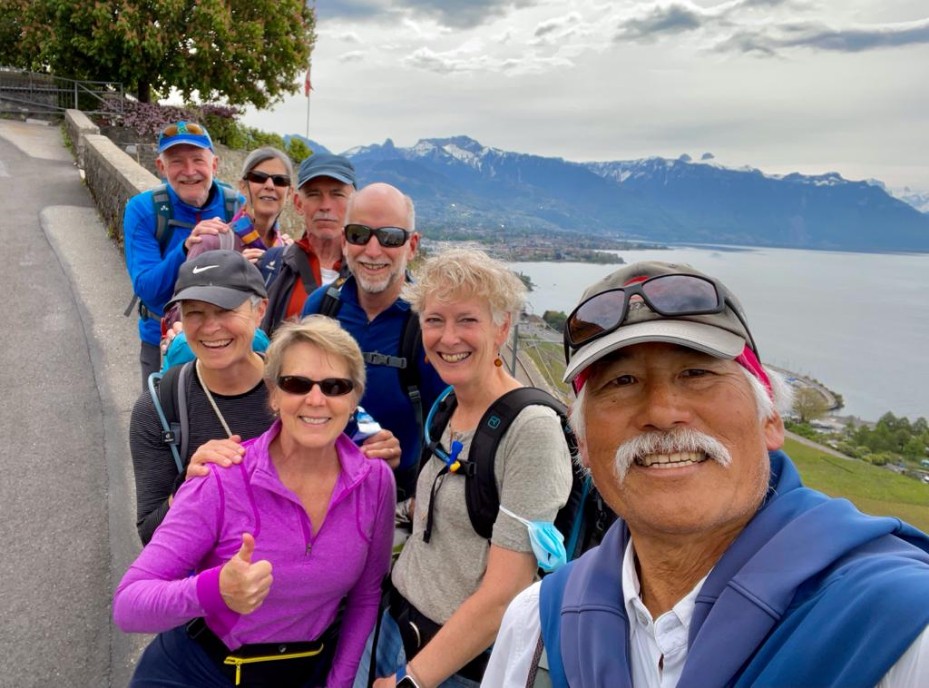 Steps for Cancer Support participants pose for a group selfie next to a lake in Geneva Switzerland