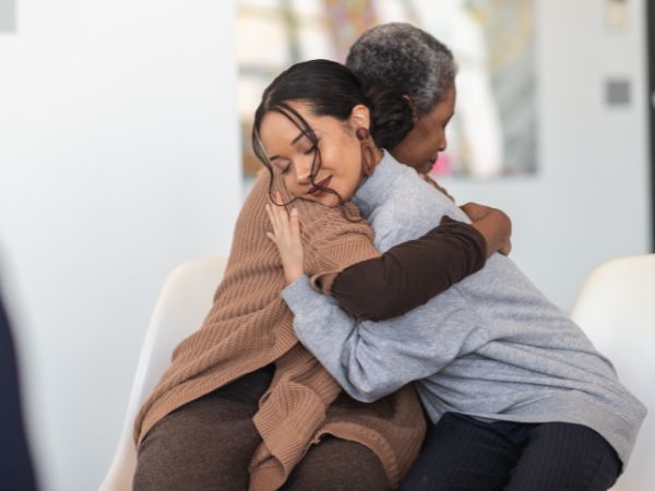 two ladies sitting hugging