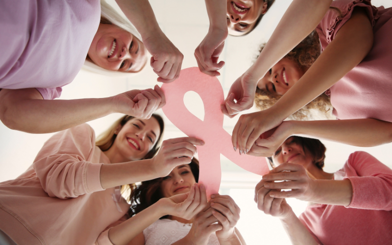 An image of Women holding a pink Ribbon for Pink October