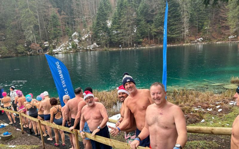 People standing by side a lake getting ready to do their cold swim in support of Cancer Support Switzerland